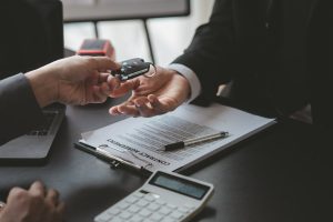 A car rental company employee pointed out the renter to sign the rental agreement after discussing t